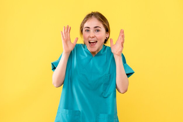 Front view female doctor rejoicing on yellow background emotion medic hospital health