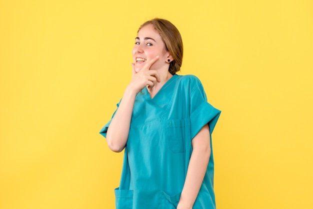 Front view female doctor smiling on yellow background hospital medic health emotion