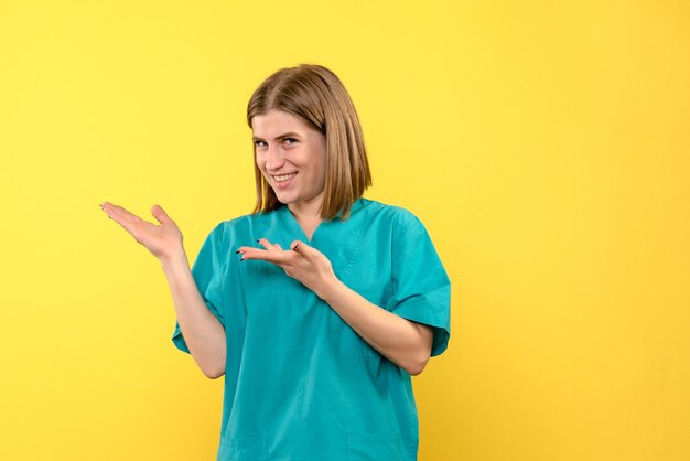 Front view female doctor smiling on yellow space