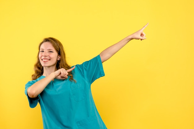 Free Photo front view female doctor smiling on a yellow space