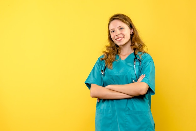 Free photo front view of female doctor smiling on the yellow wall