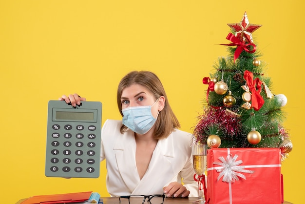 Free photo front view female doctor in sterile mask holding calculator