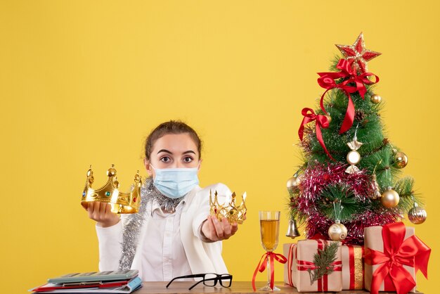 Front view female doctor in sterile mask holding crowns