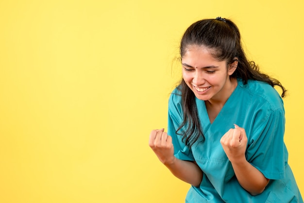 Front view female doctor in uniform showing winning gesture standing