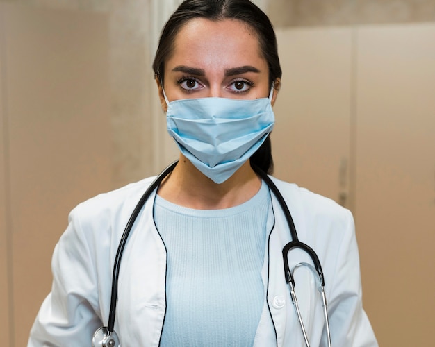 Free photo front view female doctor wearing medical mask