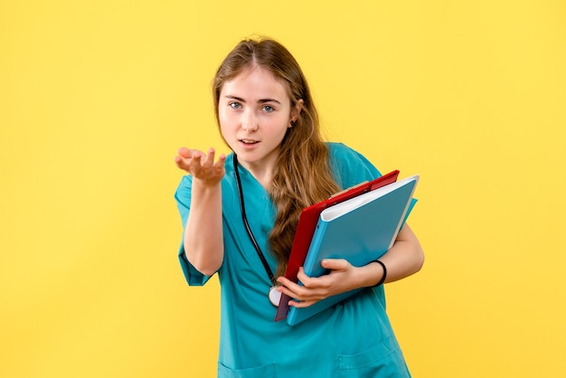 Front view female doctor with analyzes on a yellow background nurse medic hospital health