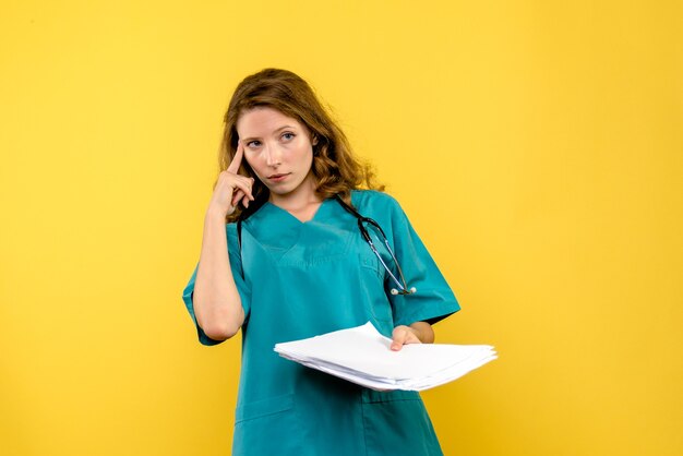 Front view female doctor with files on yellow space