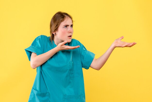 Front view female doctor on yellow background health medic emotion hospital