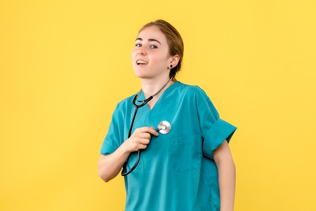 Front view female doctor on yellow background medic emotion hospital health