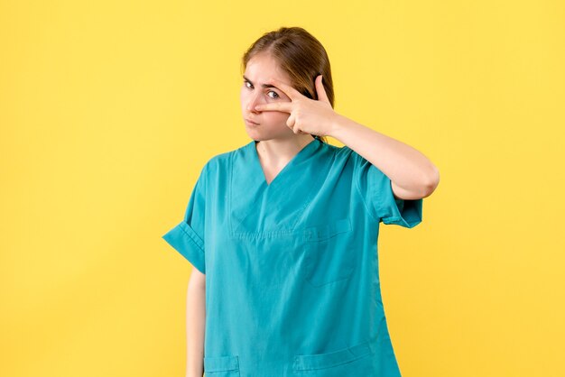 Front view female doctor on yellow background medic health emotion hospital