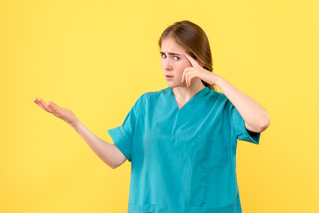 Front view female doctor on a yellow desk medic health emotions hospital