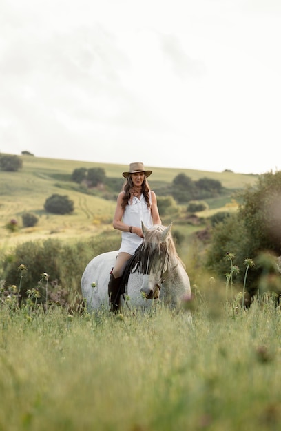 Front view of female farmer horseback riding