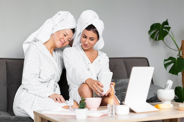 Free photo front view of female friends indulging in skin care