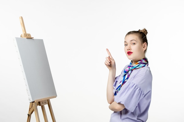 Free photo front view female painter with easel for painting on white background drawing art photo artist paint draw picture tassel