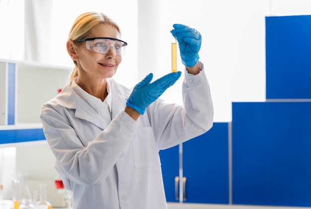 Free photo front view of female scientist with surgical gloves looking at substance