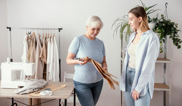 Front view of female seamstress in the studio with client