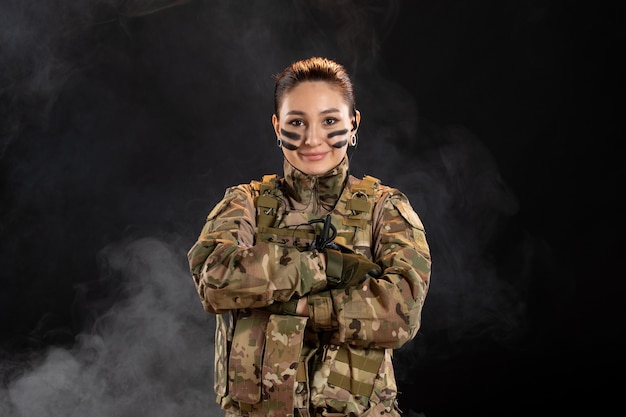 Free photo front view of female soldier in camouflage on dark wall