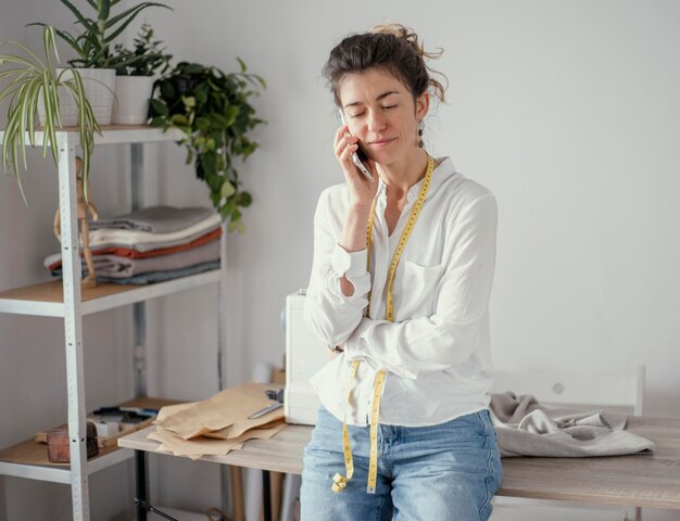 Front view of female tailor talking on the phone