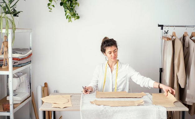 Free photo front view of female tailor working in the studio