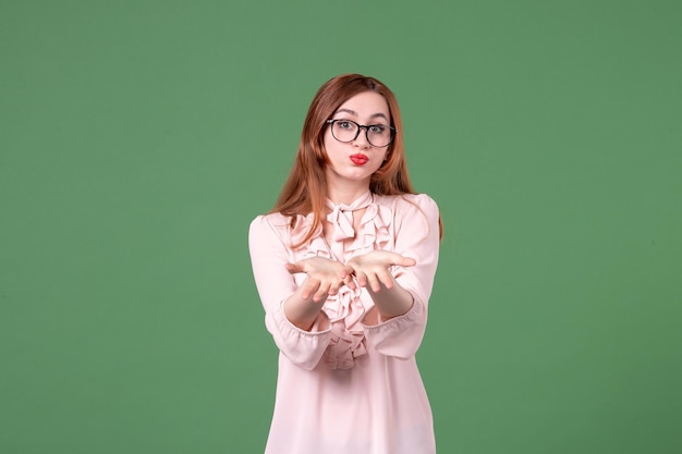 Front view female teacher in pink blouse on green background book student job school college lesson color work woman young