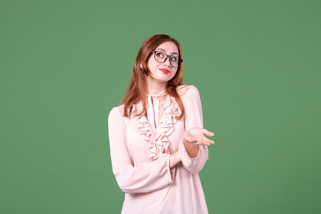 Front view female teacher in pink blouse on green background library college lesson colors work book job young school woman student