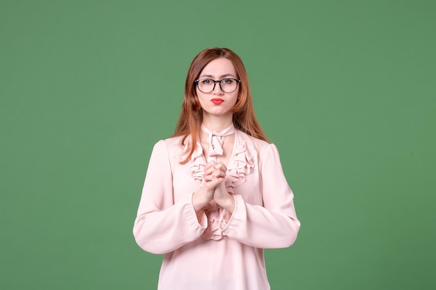 Front view female teacher in pink blouse on green background work book student job woman young lesson college color school