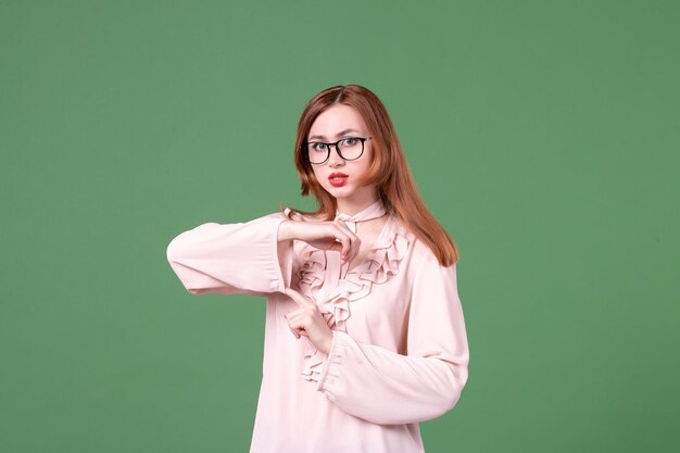 Front view female teacher in pink blouse on green