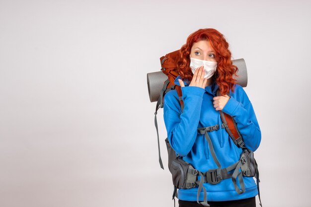 Front view female tourist going in mountain trip in mask with backpack