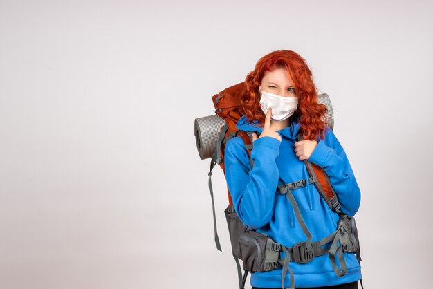 Front view female tourist going in mountain trip in mask with backpack