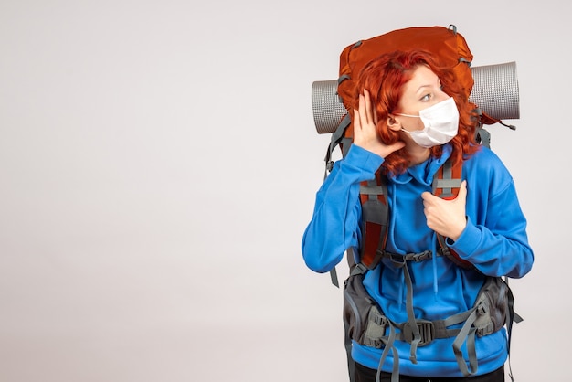 Free Photo front view female tourist going in mountain trip in mask with backpack