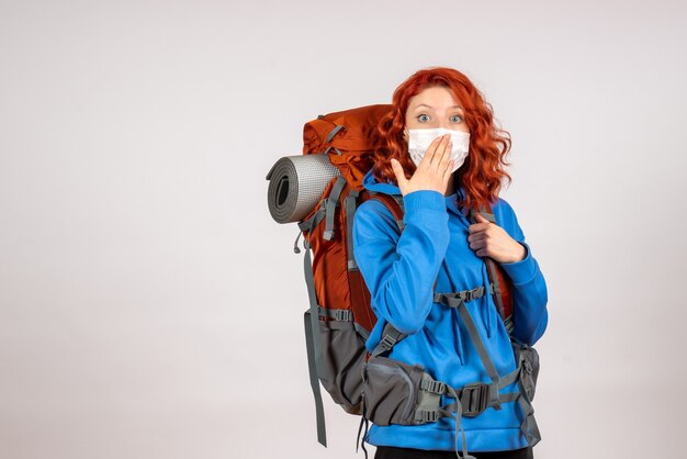 Front view female tourist going in mountain trip with backpack