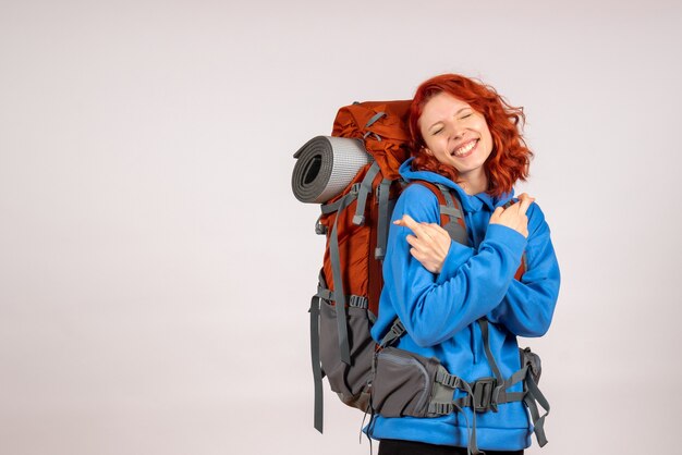 Front view female tourist going in mountain trip with backpack