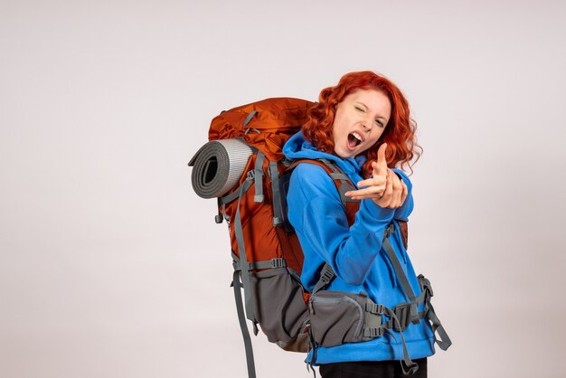 Front view female tourist going in mountain trip with backpack