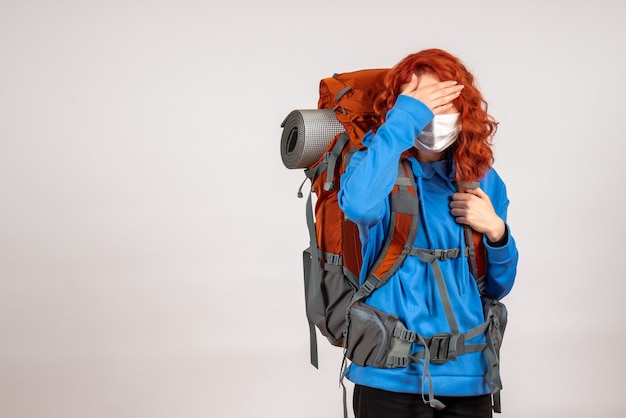 Front view female tourist going in mountain trip with backpack