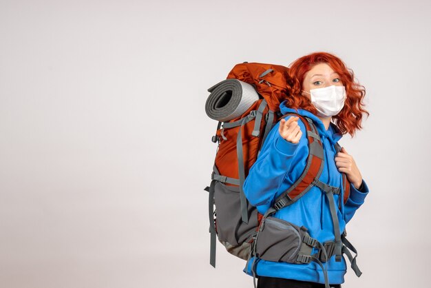 Front view female tourist going in mountain trip with backpack