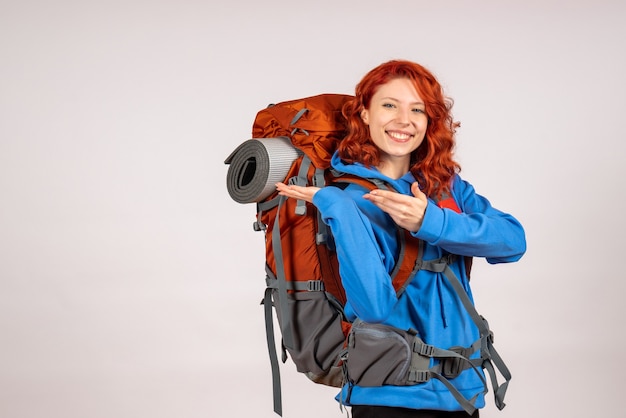 Front view female tourist going in mountain trip with backpack