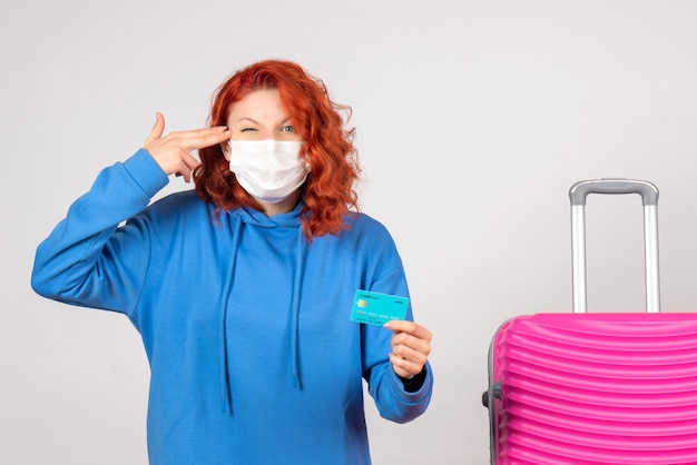 Free photo front view female tourist holding bank card in mask