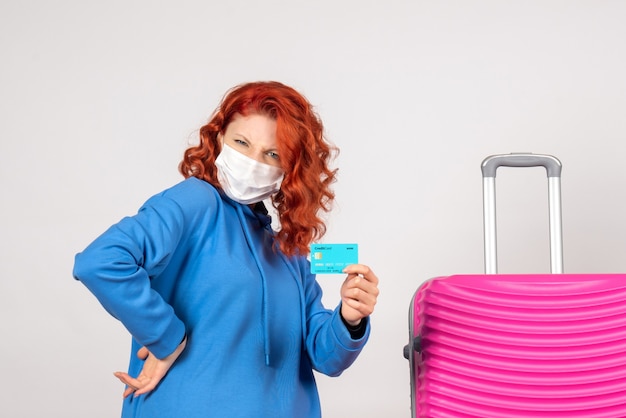 Free photo front view female tourist in mask holding bank card