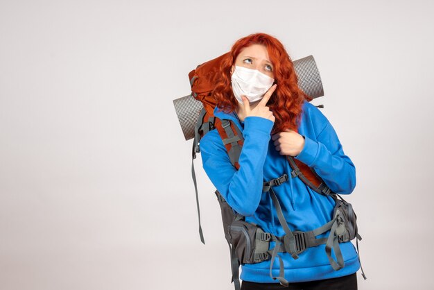 Front view female tourist in mask with backpack