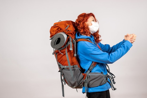 Free Photo front view female tourist in mask with backpack