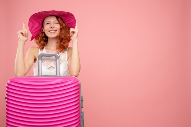 Free photo front view of female tourist with pink bag on pink wall