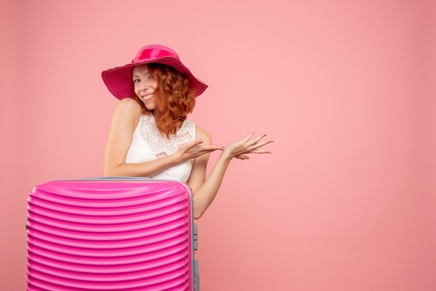 Free photo front view of female tourist with pink bag on pink wall