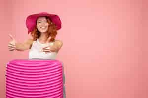 Free photo front view of female tourist with pink bag on pink wall