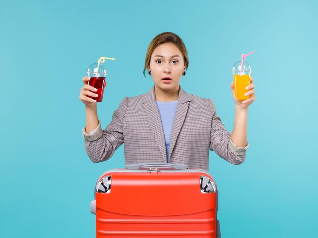 Free photo front view female in vacation holding fresh drinks on blue background trip voyage vacation travel sea plane