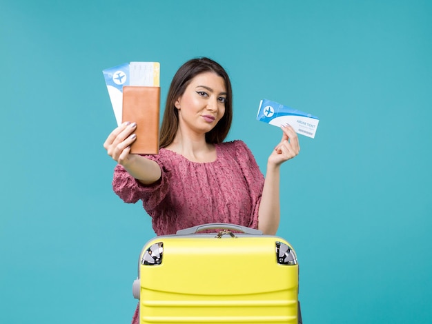 Front view female in vacation holding her tickets on blue desk journey sea woman trip vacation summer