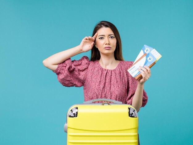 Front view female in vacation holding her tickets on blue desk journey summer trip woman sea vacation