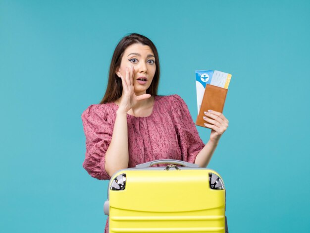 Front view female in vacation holding her wallet and tickets on blue background journey trip woman summer sea vacation