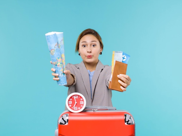 Free photo front view female in vacation holding map and tickets on blue floor plane voyage sea travel trip vacation