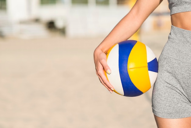 Free Photo front view of female volleyball player on the beach holding ball with copy space