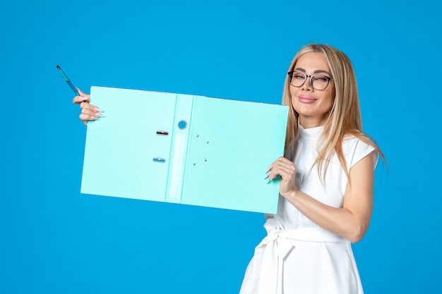 Free Photo front view of female worker in white dress holding open folder on blue wall